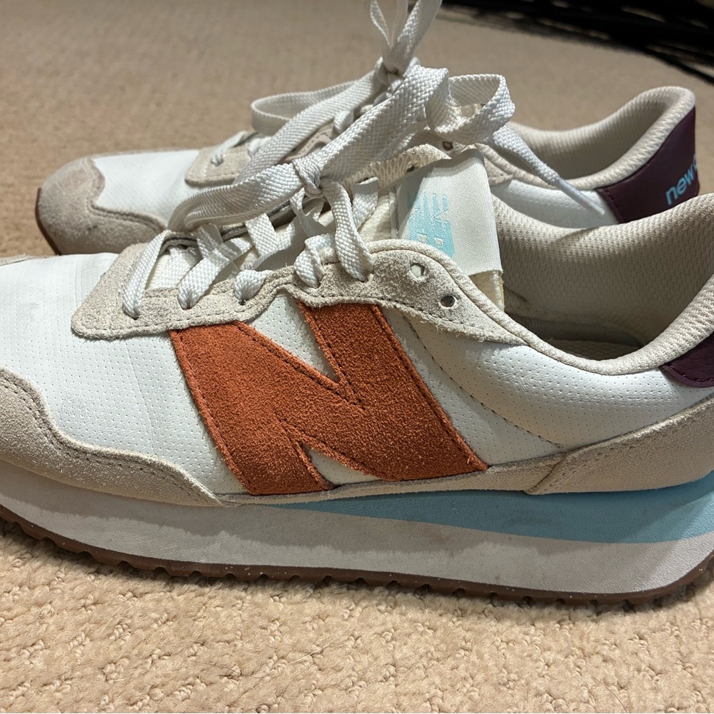 New Balance 237s. Neutral with pop of orange and blue.